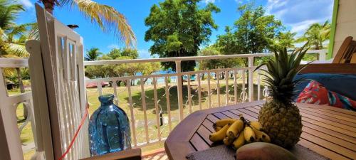 un tavolo con ananas e banane su un balcone di Studio Sable 2/4 pers face à la mer a Sainte-Anne