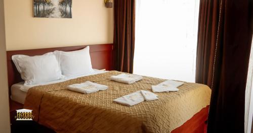 a hotel room with a bed with towels on it at Hotel Parlament in Prishtinë