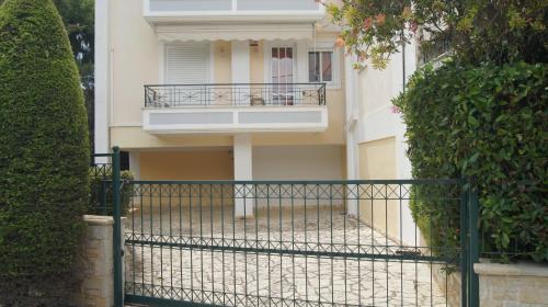 a white building with a balcony and a fence at Electra in Saronida