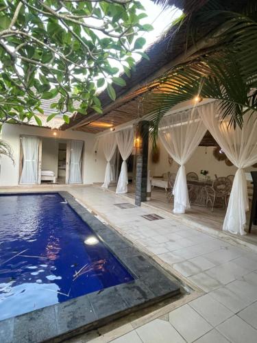 a swimming pool in the middle of a house at Hamra Villa in Jimbaran