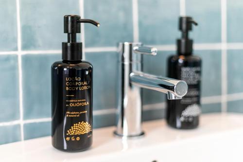 two bottles of soap sitting on a bathroom sink at Solar Branco Eco Estate in Ponta Delgada