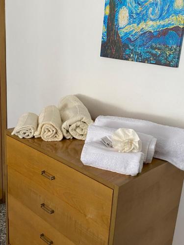 uma cómoda de madeira com toalhas por cima em Tra mare e arte em Lido di Ostia