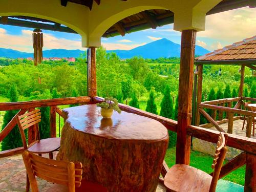 a porch with a table and chairs on a tree stump at Etno selo Stanojevic in Boljevac