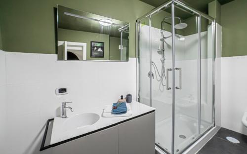 La salle de bains est pourvue d'un lavabo et d'une douche. dans l'établissement GLIKA APPARTAMENTO NAPOLETANO, à Naples