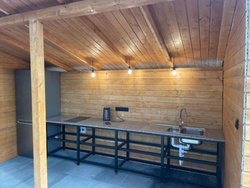 een keuken met een aanrecht in een kamer met houten wanden bij Camping nad Warta 