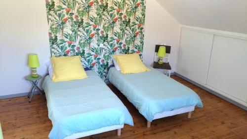 two beds with yellow pillows in a room at Les rosieres 2 