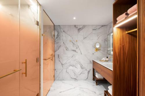 a bathroom with a shower and a sink at HONEYROSE Hotel, Montreal, a Tribute Portfolio Hotel in Montréal