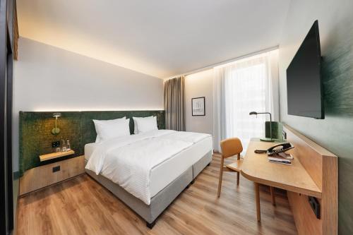 埃施伯恩的住宿－H+ Hotel Frankfurt Eschborn，酒店客房配有一张床、一张书桌和一台电脑