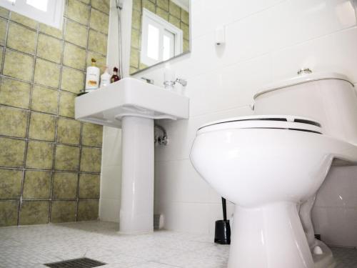 La salle de bains est pourvue de toilettes blanches et d'un lavabo. dans l'établissement Br. Guesthouse Hongdae, à Séoul