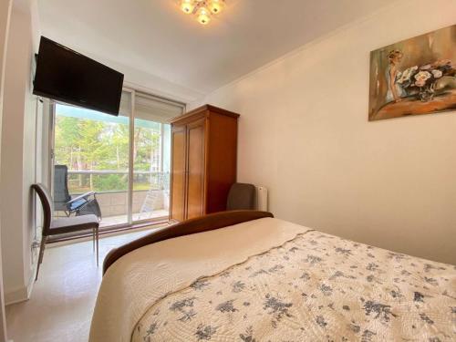 une chambre avec un lit et une fenêtre dans l'établissement Calme et verdoyant: Appart 2 pièces, terrasse, parking, proche plage et commerces - FR-1-245-74, à La Baule