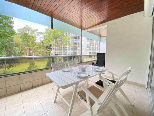 une table blanche et des chaises sur un balcon dans l'établissement Calme et verdoyant: Appart 2 pièces, terrasse, parking, proche plage et commerces - FR-1-245-74, à La Baule