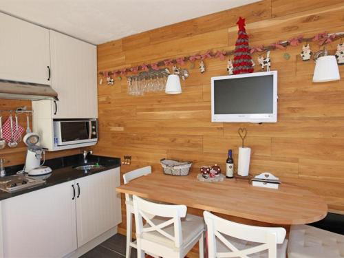 une cuisine avec une table et un arbre de Noël sur le mur dans l'établissement Studio cosy pour 2 à Avoriaz, balcon exposé sud, commerces et pistes à proximité - FR-1-314-177, à Avoriaz