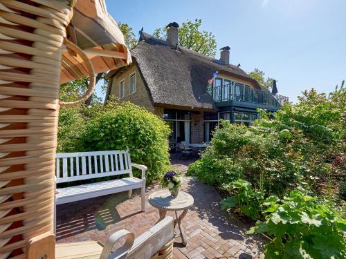 eine Bank auf einer Terrasse vor einem Haus in der Unterkunft Kapitäns Hus - Ferienhaus mit Wellness und Wasserblick in Lauterbach