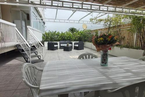a table with a vase of flowers on a patio at Dimarù in Gragnano