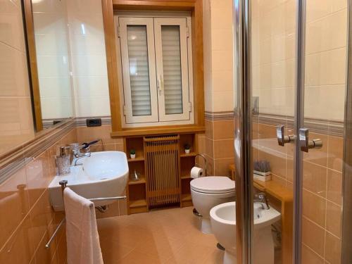 a bathroom with a sink and a toilet and a mirror at Dimarù in Gragnano