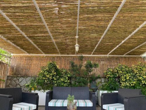 a patio with chairs and plants and a wooden ceiling at Dimarù in Gragnano