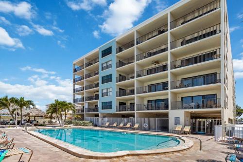 a large apartment building with a swimming pool at 201 Sandy Shores Condos in St. Pete Beach