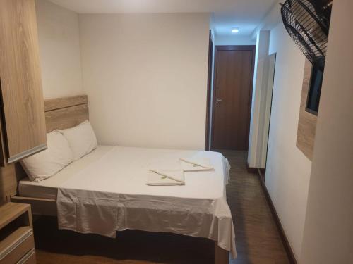 um pequeno quarto com uma cama com dois guardanapos em Hotel Wilson em Teixeiras