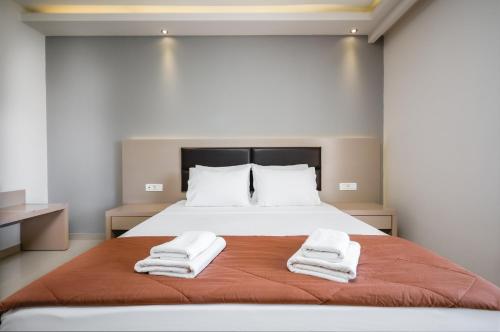 a bedroom with a bed with towels on it at Vice Hotel in Laganas