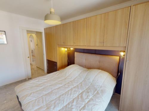 - une chambre avec un grand lit et des placards en bois dans l'établissement Spacieux 2P climatisé avec terrasses et garage, proche centre de Menton et plages - FR-1-196-332, à Menton