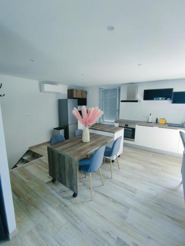 une cuisine avec une table en bois et des chaises bleues dans l'établissement Gite du moulin brochat, à Saint-Jean-de-Vaux