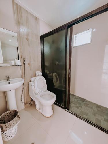 a bathroom with a toilet and a shower and a sink at A Villas Resort & Restaurant in Zamboanguita