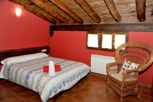 a bedroom with a bed and a chair at LA CABAÑA DE SARA in Vinuesa