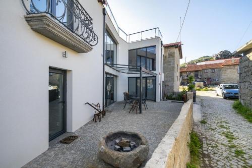 a house with a fire pit in the courtyard at Isatour -Natural Park House in Vouzela