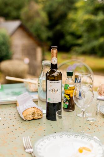 une bouteille de vin posée sur une table avec des verres dans l'établissement La Métairie Saint-Michel de Quinipily - Les Gîtes de KEROUZEC - Nature et détente, à Baud