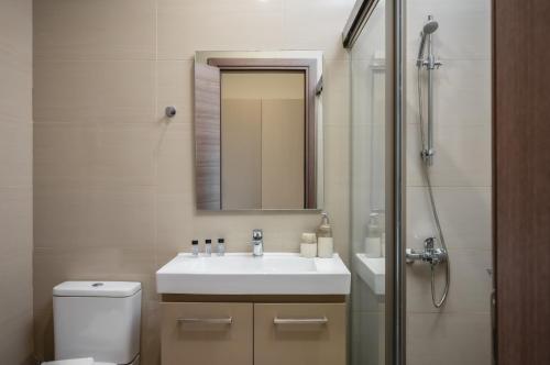a bathroom with a sink and a toilet and a mirror at Vice Hotel in Laganas
