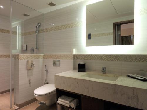 a bathroom with a toilet and a sink and a mirror at Fairfield by Marriott Visakhapatnam in Visakhapatnam