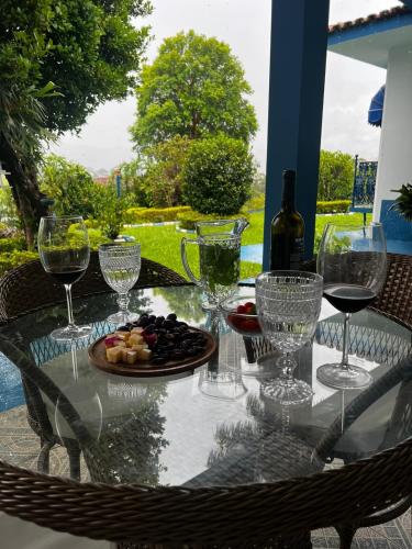 a glass table with wine glasses and a plate of fruit at Chácara das Araras in Lindóia