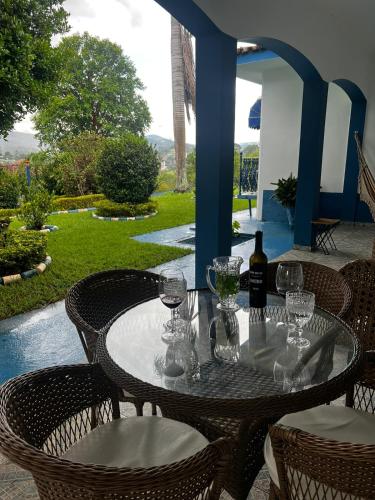 a table with wine glasses and a bottle of wine at Chácara das Araras in Lindóia