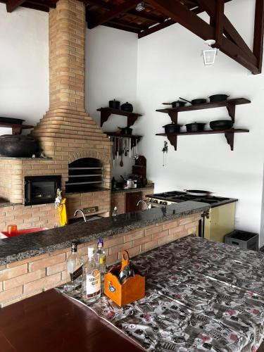 a kitchen with a stove and a brick fireplace at Chácara das Araras in Lindóia
