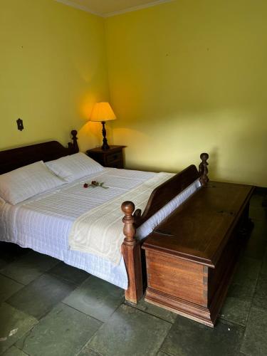 a bedroom with a bed and a table with a lamp at Chácara das Araras in Lindóia