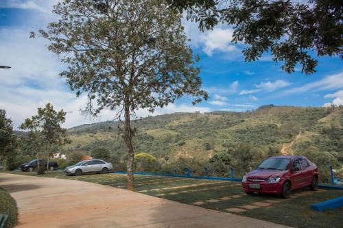 a red car parked next to a tree at Chácara das Araras in Lindóia