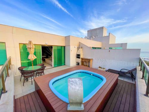 a pool on a deck with a table and chairs at Cobertura Luxo Sophia I - Orla Praia Grande in Arraial do Cabo