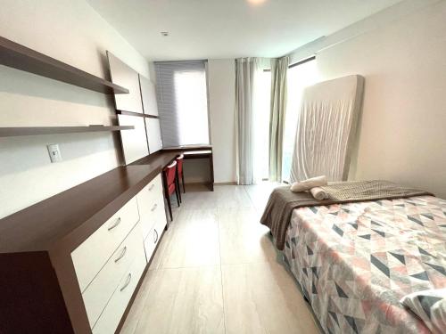 a bedroom with a bed and a dresser in it at Cobertura Luxo Sophia I - Orla Praia Grande in Arraial do Cabo