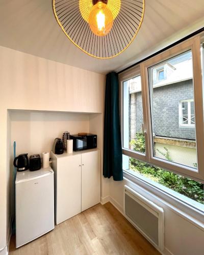 Cette chambre comprend 2 réfrigérateurs et une fenêtre. dans l'établissement Les 4 saisons Honfleur - Studio 1, à Honfleur