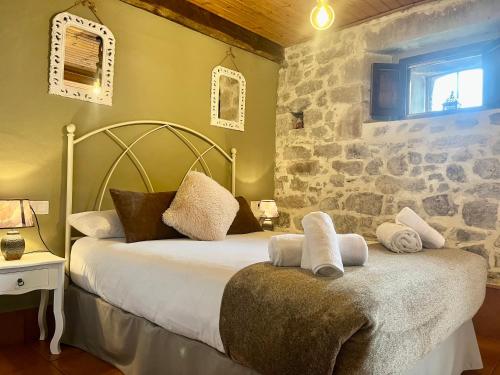 a bedroom with a bed with a stone wall at LOFT NORDESTE in Lastres