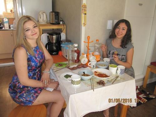 two women sitting at a table with food at Br. Guesthouse Hongdae in Seoul