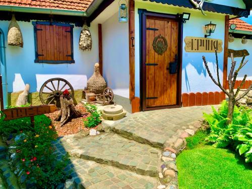 a house with a wooden door and a yard at Etno selo Stanojevic in Boljevac