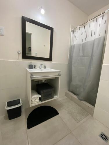ein Bad mit einem Waschbecken und einer Dusche mit einem Spiegel in der Unterkunft Fama Suite YB in La Rinconada
