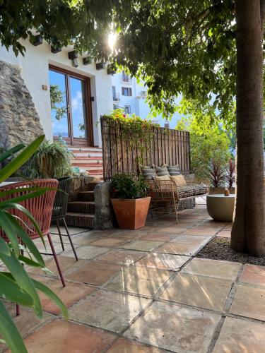 a patio with benches and plants and a tree at Hostal del vino LA COSTERA in Altea