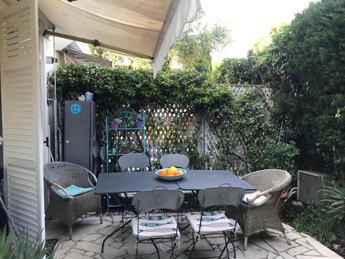 聖讓卡弗爾拉的住宿－"L'olivadou" ST JEAN CAP FERRAT，庭院里的桌椅和一碗水果