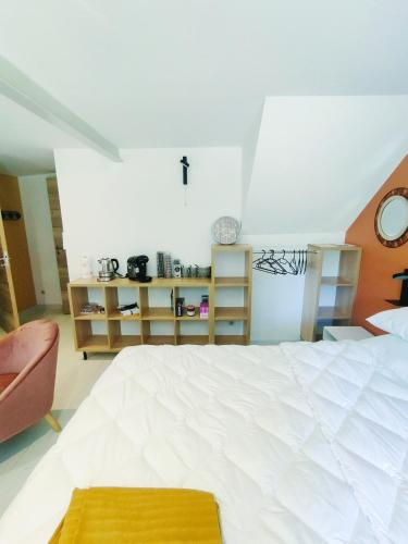a bedroom with a large white bed and a chair at chambre du moulin brochat 2 in Saint-Jean-de-Vaux