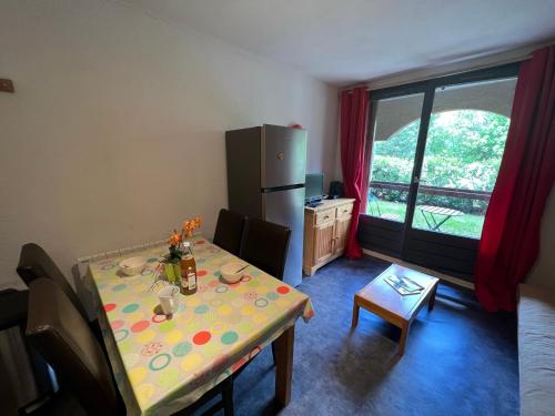 une salle à manger avec une table et un réfrigérateur dans l'établissement Grand Sud, à La Salle Les Alpes