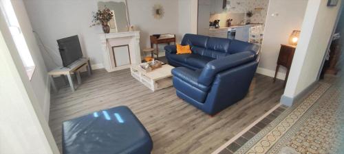 un soggiorno con divano blu e camino di L'esperance 2 a Haybes