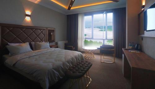 Habitación de hotel con cama y ventana grande en SIRT BUTİK HOTEL, en Akcaabat