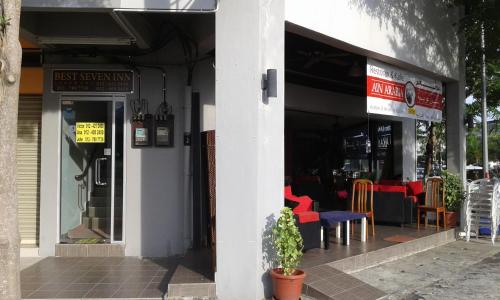 a building with a restaurant with red chairs in it at Best Seven Inn in Kuah
